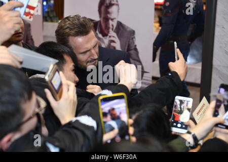 Hollywood Schauspieler Liam Neeson Autogramme für die Fans, als er auf dem roten Teppich zur Premiere seines neuen Films "Der Grenzgänger" in Peking, China ankommt Stockfoto