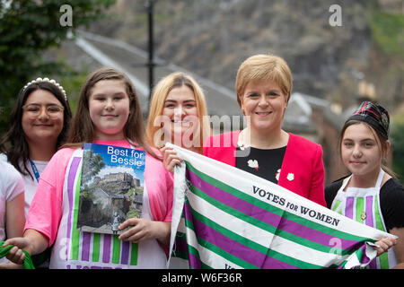Erster Minister Nicola Sturgeon (Zweiter von rechts) wurde von Jugendlichen aus den 6 VT Edinburgh Jugend Cafe kam das Buch "Am besten für Bessie' und eine Gedenktafel enthüllen, Bessie Watson's (b 1900-1992) Schottland jüngste Suffragette am Vennel in Edinburgh zu starten. Stockfoto