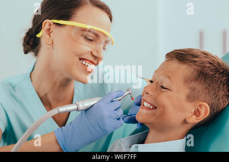 Lachende junge erste Zähne Behandlung in der Zahnarztpraxis Stockfoto