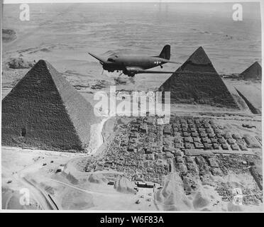 Eine Air Transport Command Flugzeug fliegt über die Pyramiden in Ägypten. Mit dringenden Krieg Lieferungen und Materialien geladen, dieses Flugzeug ist Teil einer Flotte fliegen Sendungen aus den USA über den Atlantik und den Kontinent Afrika zu strategischen Kampfzonen.; Allgemeine Hinweise: Verwenden Sie Krieg und Konflikt Nummer 1015 bei der Bestellung eine Reproduktion oder Anforderung von Informationen zu diesem Bild. Stockfoto