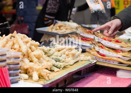Busan, Korea, 22.12.2018, Mann an einige Essen auf einem Straßenmarkt in Busan zeigt. Stockfoto