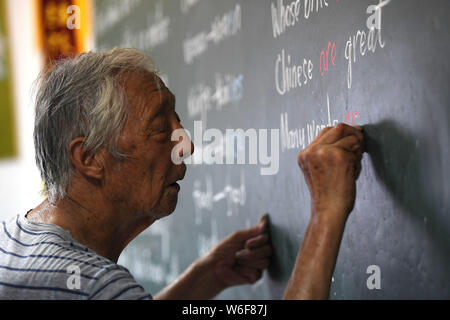 (190801) -- HEXIAN, August 1, 2019 (Xinhua) - Ihr lianping bereitet sich auf Englisch Klasse am nächsten Tag in der Klasse der 'Zuhause für Kinder' links hinter in Buchen Dorf Hexian County in der ostchinesischen Provinz Anhui, 30. Juli 2019. Ihr lianping, einen 92-jährigen pensionierten Lehrer in Buchen Dorf Hexian County, Einrichten der 'Home links hinter Kindern" im Jahr 2000, um sie zu unterrichten Englisch Unterricht für Sie kostenlos. Wie die meisten jungen Menschen Arbeit weit entfernt, Ältesten und Kinder hinter sind im Dorf links. Ohne Kind selbst, Ihr lebt mit seiner Frau in einem shanty Haus vor 30 Jahren gebaut, wo er bieten Stockfoto