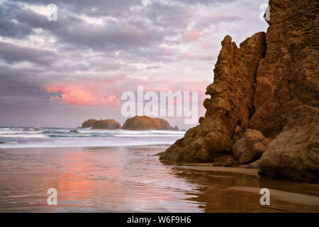 Abend glühen auf den vielen sea Stacks an den Bandon Beach inklusive Offshore Face Rock und Hut des Assistenten an der südlichen Küste von Oregon. Stockfoto