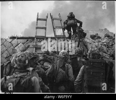 Wie gegen die Ufer von Tripolis in der Marine Hymne, Leathernecks verwenden Sturmleitern zum Sturm an Land in Inchon in Amphibischen invasion September 15, 1950. Der Angriff war so schnell, dass Opfer überraschend niedrig waren.; Englisch: Oberleutnant Baldomero Lopez, USMC, führt die 3 Platoon, Firma A, 1st Battalion, 5th Marines über die ufermauer auf der nördlichen Seite der Roten Strand, wie der zweite Angriff wave landet, 15. September 1950, während der inchon Invasion. Holz- sturmleitern sind im Einsatz ausschiffung von der LCVP, dass diese Männer an die Küste gebracht zu erleichtern. Lt. Lopez wurde in getötet Stockfoto