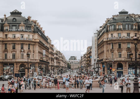 PARIS, Frankreich - Juli 19., 2014. Ein Blick auf die Avenue de l'Opera beschäftigt mit Fußgänger und Verkehr auf ein Sommertag mit hohen Wolken. Stockfoto