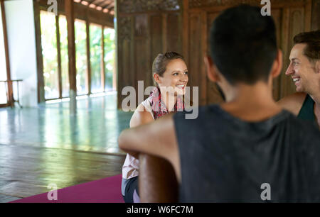 Candid shot von schönen weiblichen Meditation Lehrer diskutieren mit mixed-race männlichen Studenten über Yoga Kurs und indonesische Kultur in Bali. Stockfoto