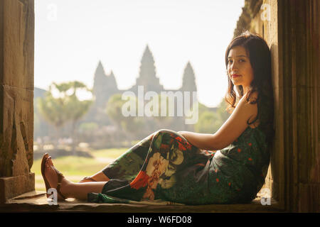 Candid Portrait von brunette Asiatischen alleinreisende Frauen in Siem Reap, Kambodscha. Es gibt einen berühmten Angkor Wat Tempel im Hintergrund. Stockfoto