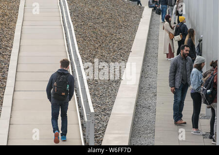 BERLIN, DEUTSCHLAND - 26. SEPTEMBER 2018: Gegensätzliche Bild einer Person allein auf eine Rampe und die Menschen in einem Korridor zu einem temporären Ständigen Stockfoto