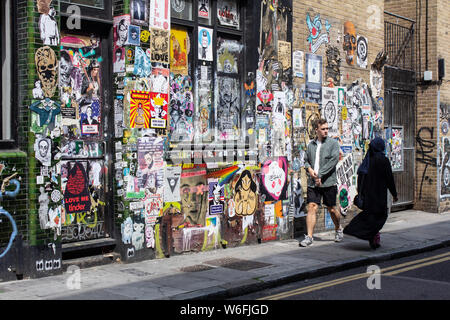 Wände mit Graffiti und Plakate in Brick Lane, London Stockfoto