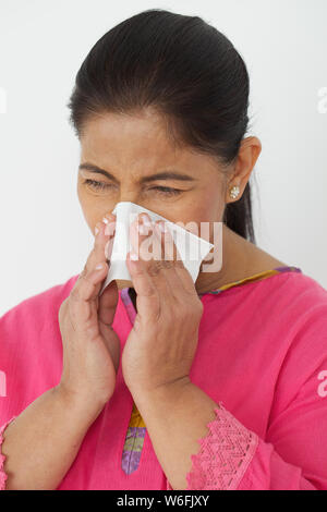 Frau bläst Nase mit Taschentuch Stockfoto