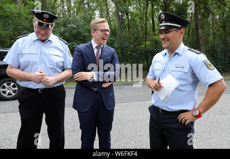 01. August 2019, Mecklenburg-Vorpommern, Löcknitz: Bodo Kaping (L-R), Präsident der föderalen Polizei Hauptquartier in Bad Bramstedt, Philipp Amthor (CDU), Mitglied des Bundestages, und Arne Burkert, Chief Beauftragten der Polizei, sprechen Sie bei einem Besuch bei einer Verkehrskontrolle durch die Bundespolizei außerhalb der deutsch-polnischen Grenze. Seit Juli hat das Bundesamt für Polizei in Pasewalk und Rostock hat zum ersten Mal hatte 30 junge Offiziere der föderalen Polizei als Verstärkung. Ziel ist es, die höhere Kriminalitätsrate im Sommer mehr wirksam zu bekämpfen und das Gefühl der Sicherheit des Peop zu erhöhen. Stockfoto