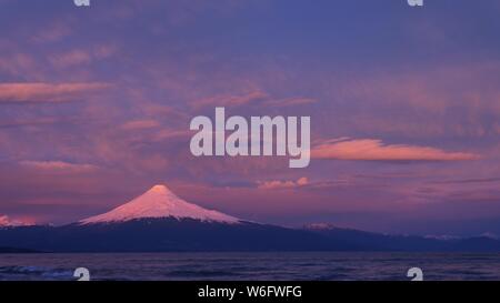 Schönen Sonnenuntergang Farben in den Himmel und über den Gletscher und Schnee auf den Vulkan Osorno Stockfoto