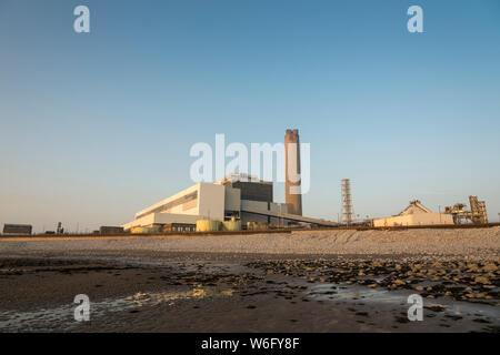 Ein Blick auf die Kohle Kohlekraftwerk Aberthaw, von den angrenzenden Strand, wenn es in blassen Abendsonne unter einem wolkenlosen blauen Himmel gebadet. Stockfoto