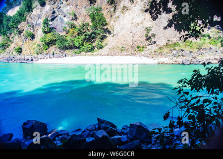 Wunderschöne Aussicht auf den ruhigen Ganges und den Strand in Rishikesh India Stockfoto