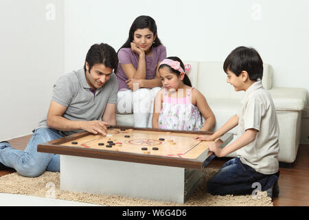 Familie spielt carrom Stockfoto