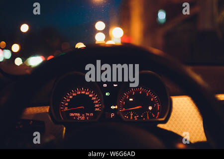 Tachometer zählen hohe Geschwindigkeit in einer schnellen Bewegung. Sportliches Fahrzeug die Zusatzinstrumente bei Nacht beleuchtet. Drehzahlmesser. Modernes Fahrzeug Cluster. Stockfoto