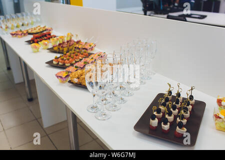 Wunderschön eingerichtete catering Bankett mit Burgern, Profiteroles, Salate und kalte Snacks. Vielzahl von leckeren Snacks auf den Tisch. Stockfoto