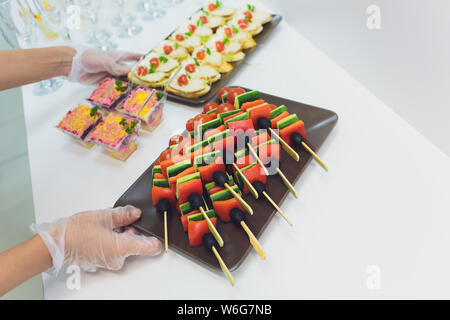 Wunderschön eingerichtete catering Bankett mit Burgern, Profiteroles, Salate und kalte Snacks. Vielzahl von leckeren Snacks auf den Tisch. Stockfoto