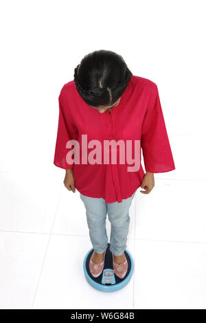 Erhöhte Ansicht einer Frau wiegen sich auf die Waage im Badezimmer Stockfoto