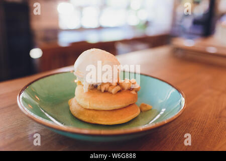 Warme Pancakes mit Butter, Sirup und Eis Creme auf Tisch lagen. Stockfoto