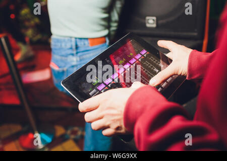 Veranstaltung Tuner controlling Sound von Tablet auf dem Hintergrund der Karaoke Bar. Stockfoto