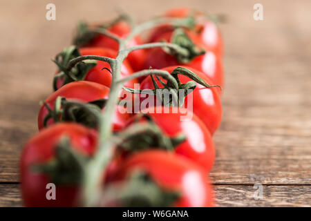Weinstock Kirschtomaten auf hölzernen Tisch Stockfoto