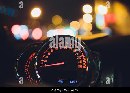 Tachometer zählen hohe Geschwindigkeit in einer schnellen Bewegung. Sportliches Fahrzeug die Zusatzinstrumente bei Nacht beleuchtet. Drehzahlmesser. Modernes Fahrzeug Cluster. Stockfoto