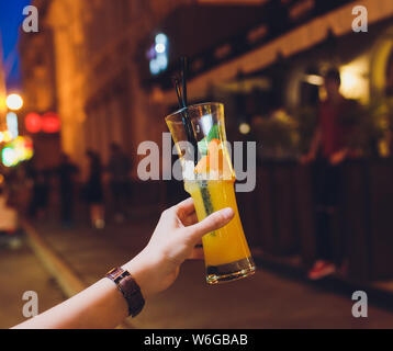 Frau Hand orange Cocktail mit Minze in highball Glas eingerichtet. Stockfoto