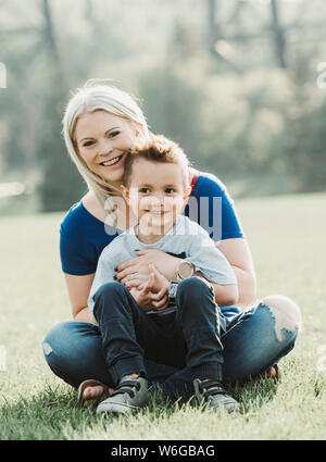 Porträt der Mutter mit einem jungen Sohn auf dem Rasen in einem Park; Edmonton, Alberta, Kanada Stockfoto