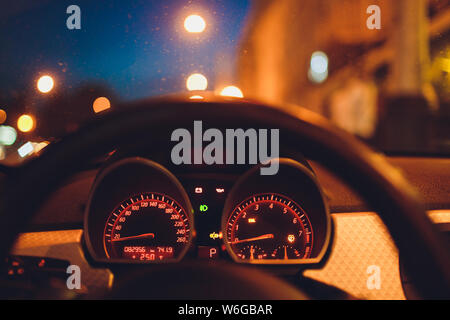 Tachometer zählen hohe Geschwindigkeit in einer schnellen Bewegung. Sportliches Fahrzeug die Zusatzinstrumente bei Nacht beleuchtet. Drehzahlmesser. Modernes Fahrzeug Cluster. Stockfoto