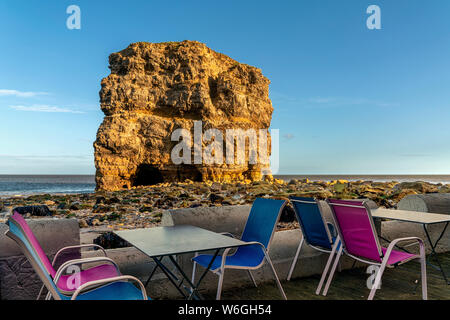 Farbenfrohe Restaurantterrasse an der Atlantikküste mit einem großen Meeresstapel an der Küste; South Shields, Tyne and Wear, England Stockfoto