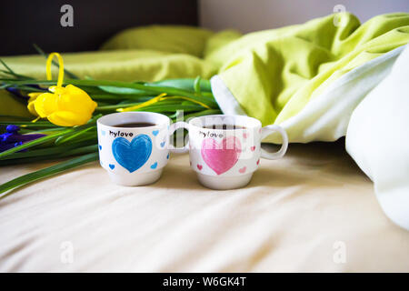 Zwei Tassen Kaffee stand auf dem Bett mit einem Blumenstrauß, close-up. Stockfoto