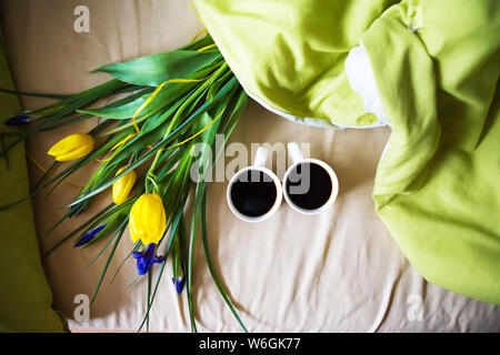 Zwei Tassen Kaffee stand auf dem Bett mit einem Blumenstrauß, close-up. Stockfoto