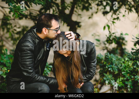 Paar in der Liebe mit gelöster Probleme, Freund Konsolen seine Freundin von ihr umarmen. Stockfoto