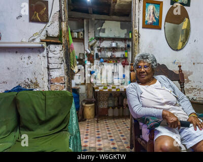 Senior kubanische Frau sitzt auf einem Stuhl in Ihrem Hause, Havanna, Kuba Stockfoto