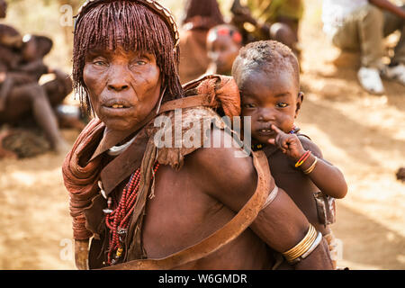 Hamer Frau, die ein Baby an einen Stier springen Zeremonie, die initiiert einen Jungen ins Mannesalter, in der Ortschaft Asile, Omo Valley Stockfoto