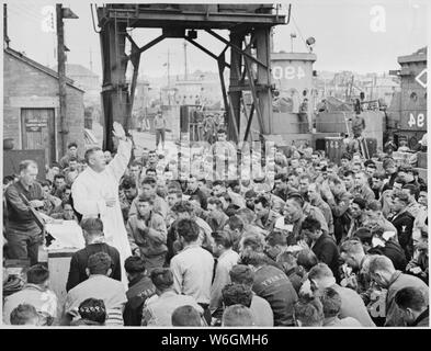 Vater (Major) Edward J. Gewässer, katholische Kaplan von Oswego, New York, führt Gottesdienst auf einem Pier für Mitglieder der ersten Angriff Truppen gegen Hitlers Truppen auf dem Kontinent geworfen. Weymouth, England.; Allgemeine Hinweise: Verwenden Sie Krieg und Konflikt Nummer 1039 bei der Bestellung eine Reproduktion oder Anforderung von Informationen zu diesem Bild. Stockfoto