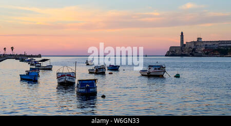 Kleine Boote im Hafen von Havanna Bucht bei Sonnenuntergang mit Morro Castle in der Ferne; Havanna, Kuba Stockfoto