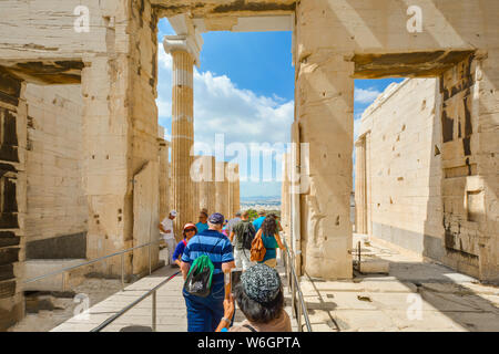 Touristen durch die antiken Ruinen auf der Akropolis in Athen, Griechenland mit modernen Stadt Athen ausgebreitet vor Ihnen. Stockfoto