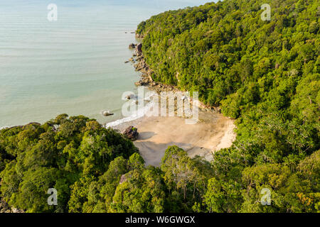 Antenne drone Ansicht einer schönen kleinen, einsamen Sandstrand in einer kleinen Bucht, die von tropischem Regenwald umgeben Stockfoto