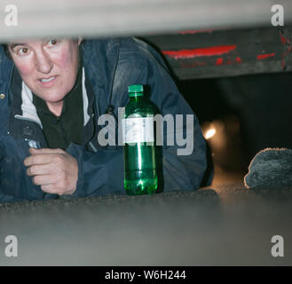 Parliament Square, London, UK. 2. Dezember 2015. Eine weibliche Demonstrant sperrt sich unter einem Lkw außerhalb der Häuser des Parlaments in Demonstrat Stockfoto