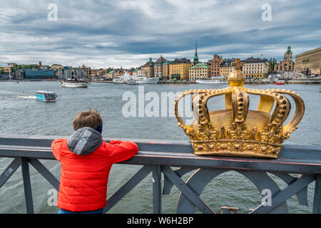 Ansicht der Rückseite des Kindes auf Brücke Skeppsholmsbron (Skeppsholm) neben dem legendären goldenen Krone, Stockholm, Schweden Stockfoto
