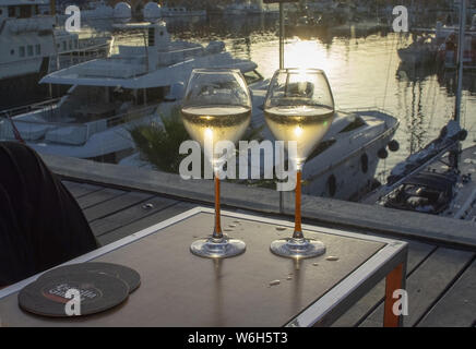 PALMA DE MALLORCA, SPANIEN - 23. JUNI 2019: zwei Gläser Champagner Flöte bei Sonnenuntergang von der Marina in der Sonne romantisch am 23. Juni 2019 auf Mallorca, Spanien Stockfoto