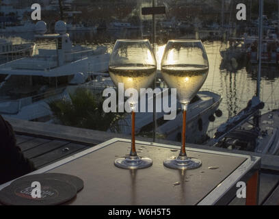 PALMA DE MALLORCA, SPANIEN - 23. JUNI 2019: zwei Gläser Champagner Flöte bei Sonnenuntergang von der Marina in der Sonne romantisch am 23. Juni 2019 auf Mallorca, Spanien Stockfoto