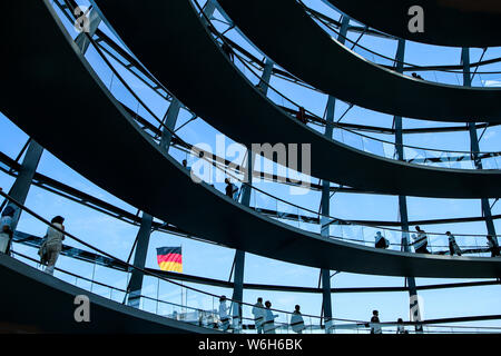 Die Details der Reichstag in Berlin. Die Glaskugel auf der Spitze mit nur Silhouetten der Menschen und eine deutsche Flagge hinter sich. Stockfoto