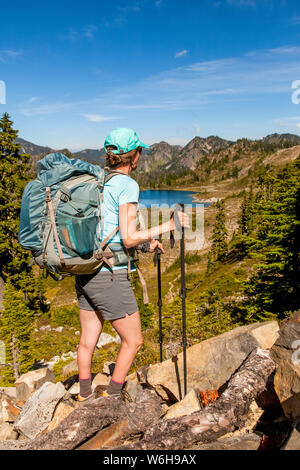 Weibliche Backpacker auf High Divide Trail pausieren, um einen Blick auf den Lunch Lake im Sommer, Seven Lakes Basin, Olympic National Park, Ol... Stockfoto