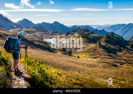 Weibliche Backpacker auf hohen Divide Trail nehmen im Hinblick auf die sieben Seen im Sommer, der Olympische National Park, Olympic Mountains Stockfoto