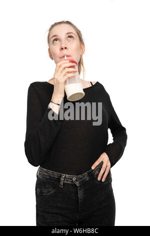 Eine junge Frau hält ein Glas Milch und Getränke Stockfoto