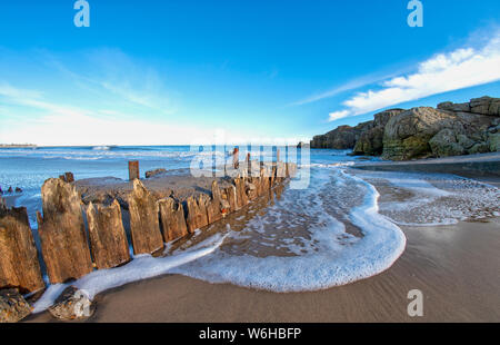 Schaum und Surfen am Strand entlang der Atlantikküste; South Shields, Tyne und Wear, England Stockfoto