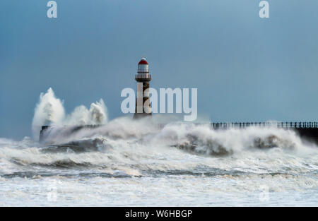 Roker Leuchtturm und Wellen aus dem Fluss Ware auf dem Pier; Sunderland, Tyne und Wear, England Stockfoto